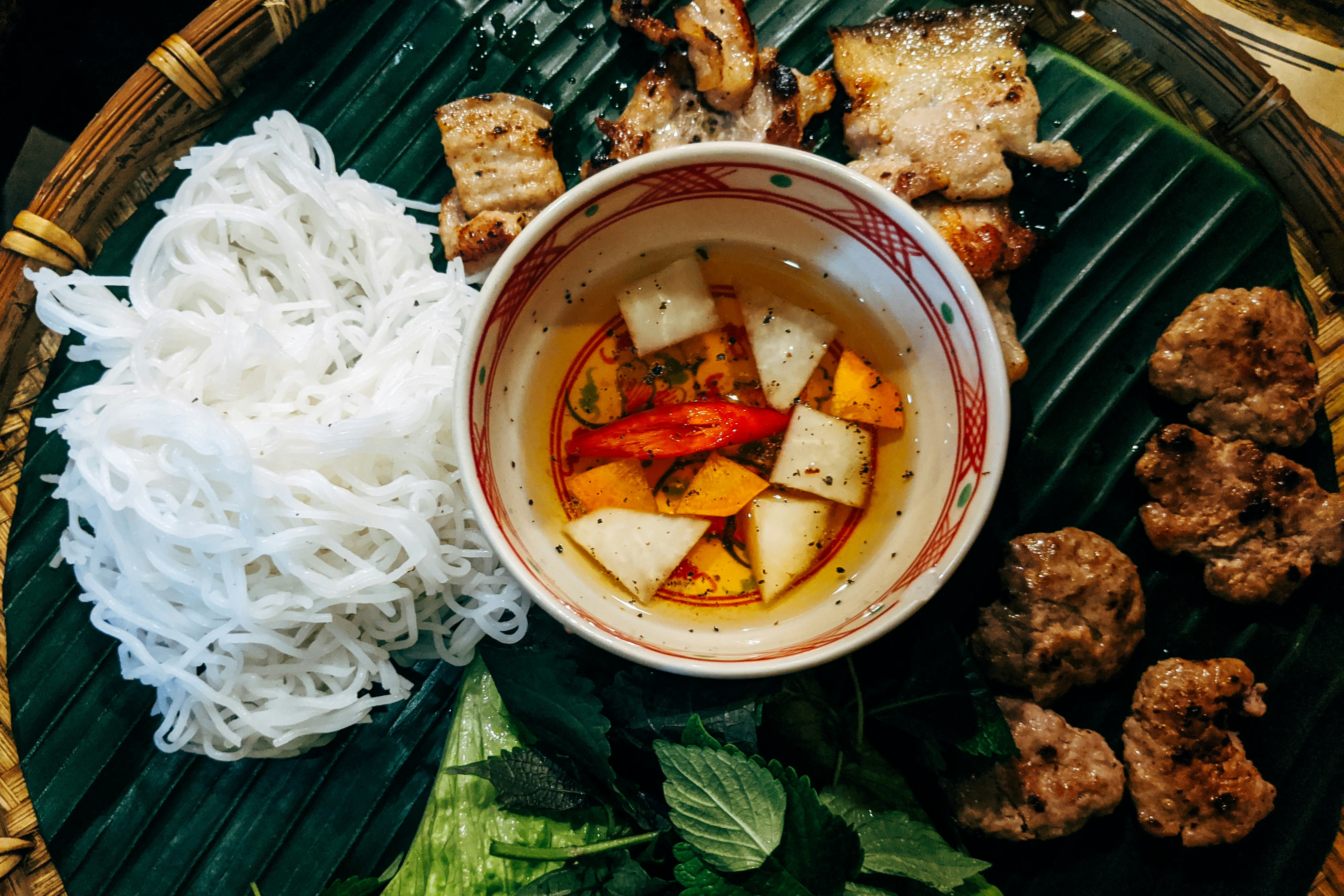 white noodles with meat and vegetables on white ceramic bowl